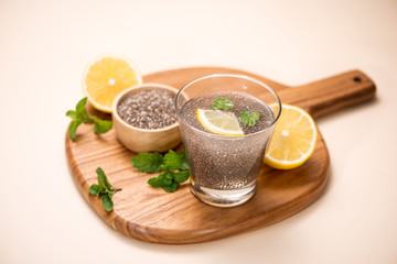 Selective focus of chia seeds drink with water in transparent glass with lemon balm.