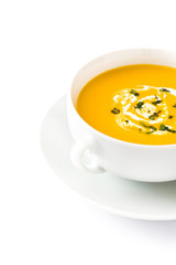 Pumpkin soup in white bowl on wooden table
