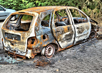 Ausgebranntes Auto, Completely burnt-out car standing as a wreck in a parking lot