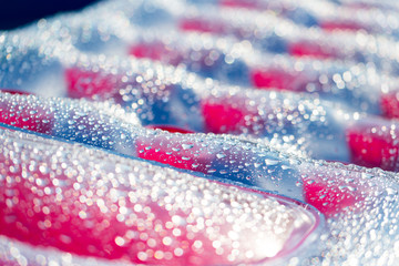 Inflatable pink and blue mattress with drops of water in the pool