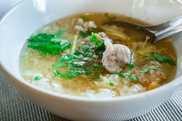 Boiled rice with pork in white bowl.