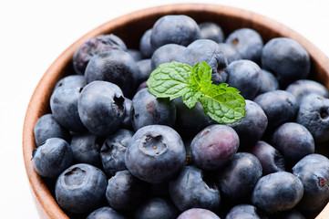 close up blueberry with vanilla mint in a wooden bowl isolated on white background
