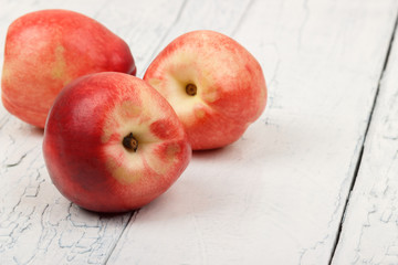 Naklejka na ściany i meble Ripe red peaches on the white wooden table