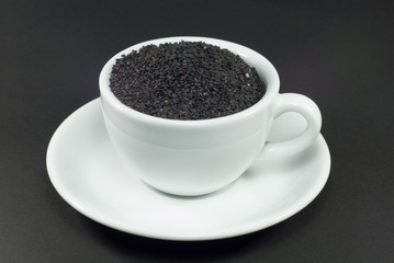 Black sesame in white cup with black background