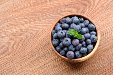 blueberry with vanilla mint in a wooden bowl on wooden background,top view