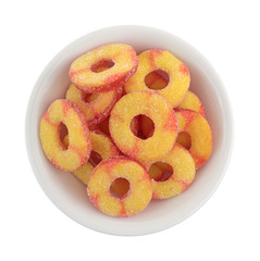 Top view of peach flavored candy in a small bowl isolated on a white background.