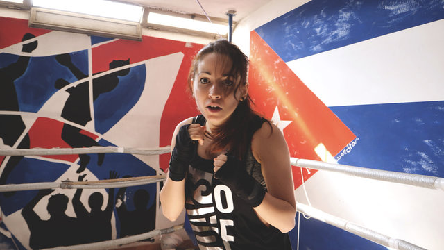 Young woman athlete doing shadow boxing exercise in a boxing club..