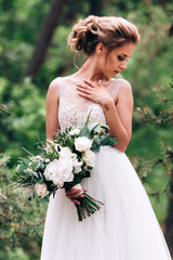 Beautiful bride in the nature in a luxurious dress