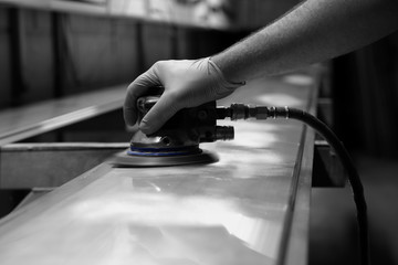 Man using orbital sander to prepare a metal panel with selective colour