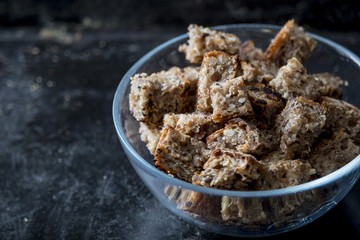 Croutons in bowl dark background