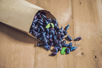 Fresh honeysuckle blue berry fruits with leaf on a wooden background