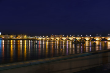 The beautiful Pont de pierre or Stone Bridge connecting the left and right banks of the Garonne River in twilight , Bordeaux , France