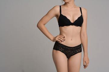 Fototapeta premium Beautiful girl with a sports figure in the studio on a white background. A beautiful figure, perfect underwear. Big breasts and a priest.