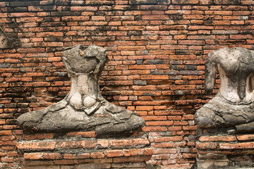 Broken statue in a temple at  Ayutthaya,Thailand (Old brick background)
