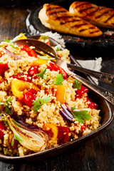 Quinoa with vegetables and chicken in background