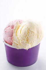 Ice cream cup on white background. Fresh organic vanilla and strawberry handmade ice cream in a purple paper cup.