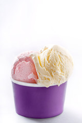 Ice cream cup on white background. Fresh organic vanilla and strawberry handmade ice cream in a purple paper cup.