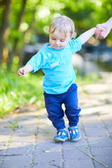 Fototapeta premium Happy baby boy playing with mom in summer park