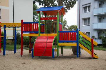 Two girls together happily sit on wooden structures on the playground
