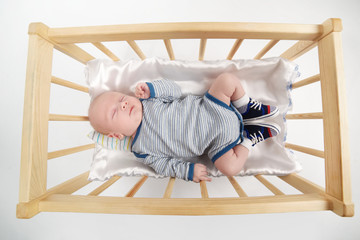 cute newborn baby in wooden bed