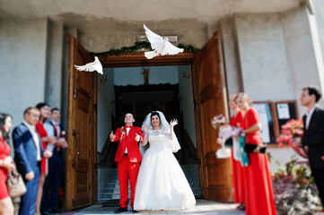 Gorgeous wedding couple releasing wedding white doves into the air.