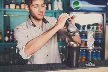 Bartender making cocktail with lime, close-up