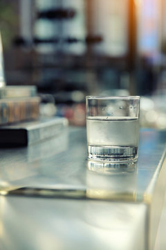 Water in glass on bar background