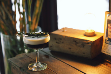 Coffee cocktail with coffee bean and rosemary on top with wood background