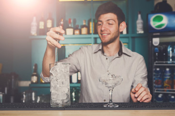 Bartender making ice for cocktail closeup