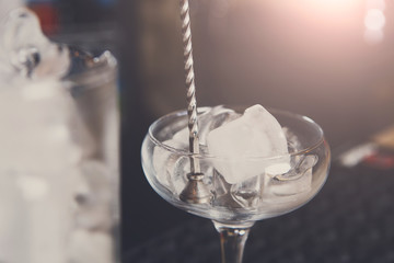 Bartender making ice for cocktail closeup