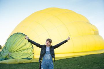 Smiling young woman standing against aerostat