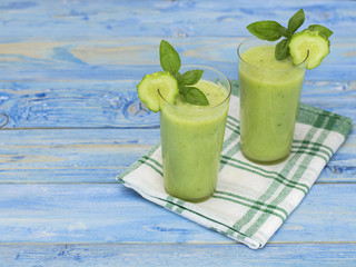 Glasses with a cucumber drink on a wooden table. 