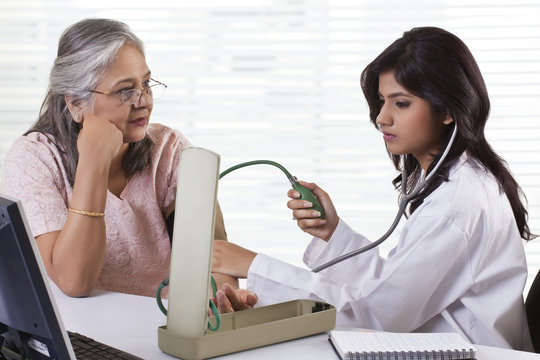 Doctor checking patient's blood pressure 