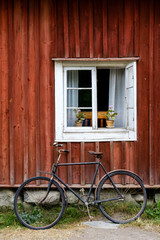 Fototapeta na wymiar Altes Fenster mit antikem Fahrrad in Schweden