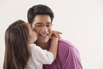 Young girl kissing her father 