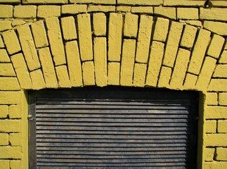 A brick arch called the window, closed the blinds