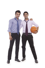 Portrait of two male executives with a basketball