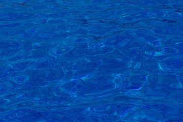 Close-up of crystal-clear water with sunshine in the swimming pool, background, texture. Swimming conception.