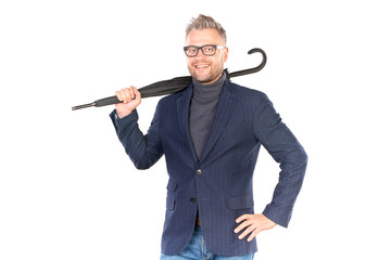 Elegant middle-aged businessman holding closed stick umbrella