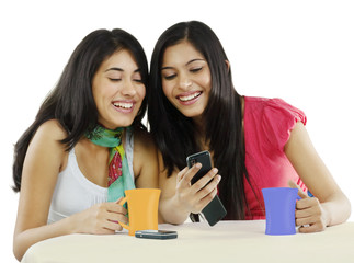 Two friends looking at a mobile phone and smiling 