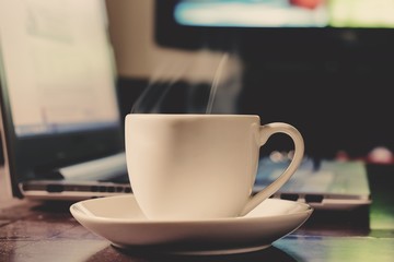 cup coffee with notebook computer on wood table