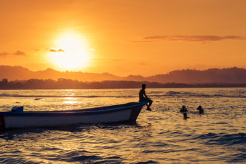 People swimming at the beach in Puerto Viejo de Talamanca, Costa Rica, at sunset