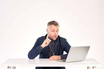 Portrait of middle-aged businessman sitting at office desk and having video call