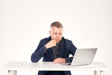 Portrait of middle-aged businessman sitting at office desk and having video call