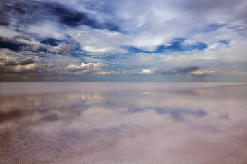 Clouds and reflections in a salt lake. Dramatic landscape.
