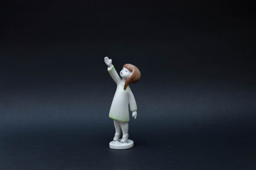 Porcelain girl figurine isolated on black background