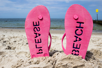 Pink flip flops on the beach - obrazy, fototapety, plakaty