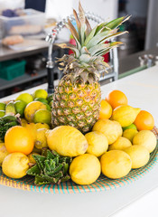 Zitronen, Ananas und Limetten in einer Schale auf der Theke