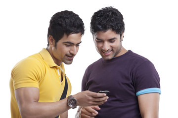 Happy friends reading text message on cell phone 