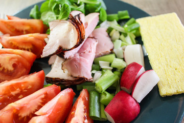 Slice of smoked meat with tomato, radish, onion and cracker